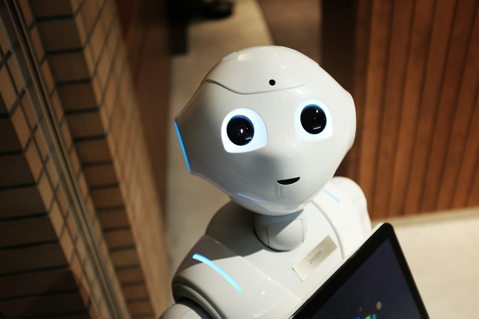 An industrial robotic arm in a softly-lit factory, representing AI agents moving from concept into real production work.